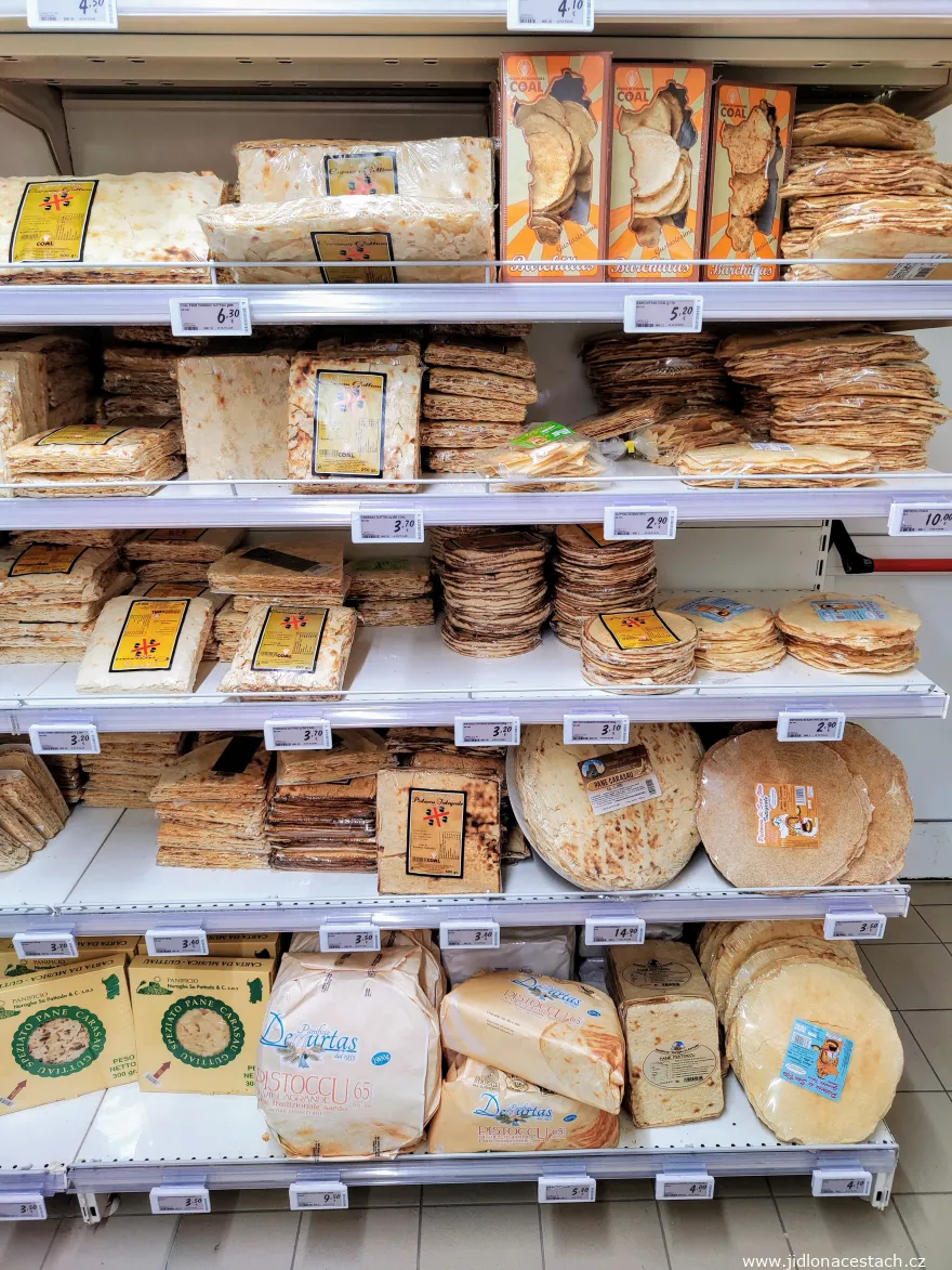 Estante de un supermercado sardo con paquetes de pane carasau, guttiau y quesos. Estante de un supermercado sardo con paquetes de pane carasau, guttiau y quesos.