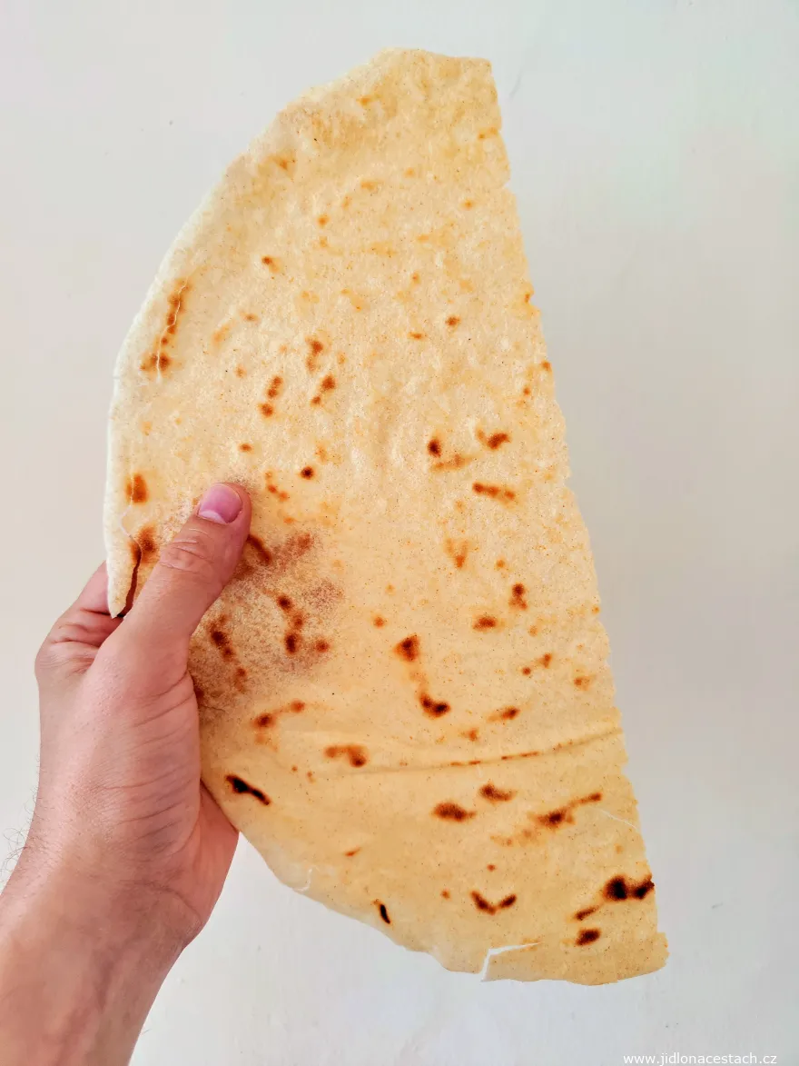 Una lámina fina y redonda de pane carasau en la mano. Una lámina fina y redonda de pane carasau en la mano.