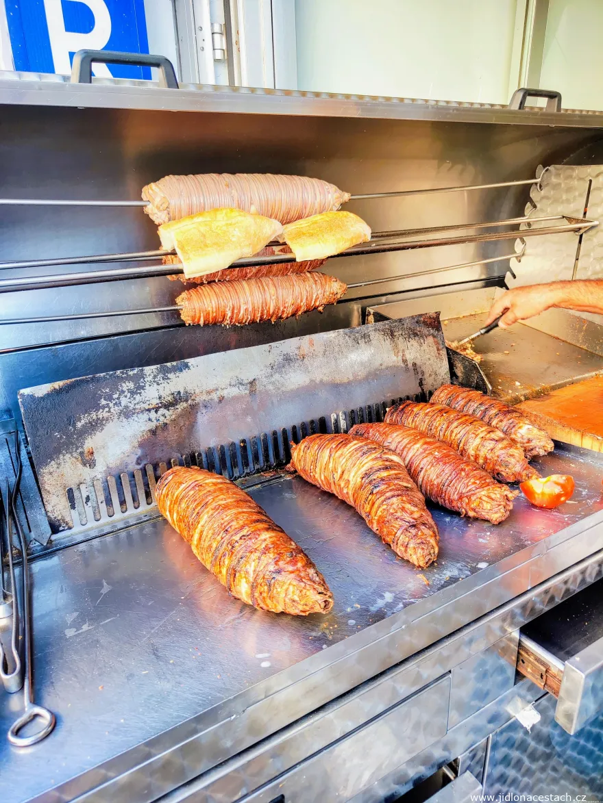 Zubereitung eines Kokoreç-Sandwichs: Das Baguette wird über Holzkohle gegrillt, eine Scheibe Kokoreç wird klein gehackt und ebenfalls gegrillt (ganz rechts).
