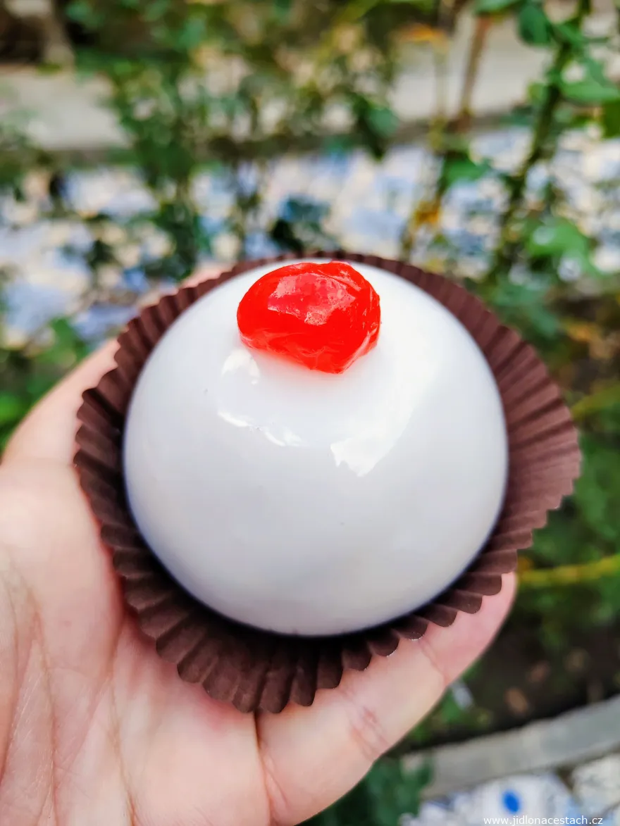 Minna di sant'Agata - a round dessert with white icing and a cherry.