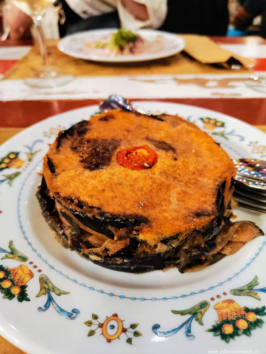 Parmigiana di melanzane - layers of baked eggplant with tomatoes and cheese on a plate.