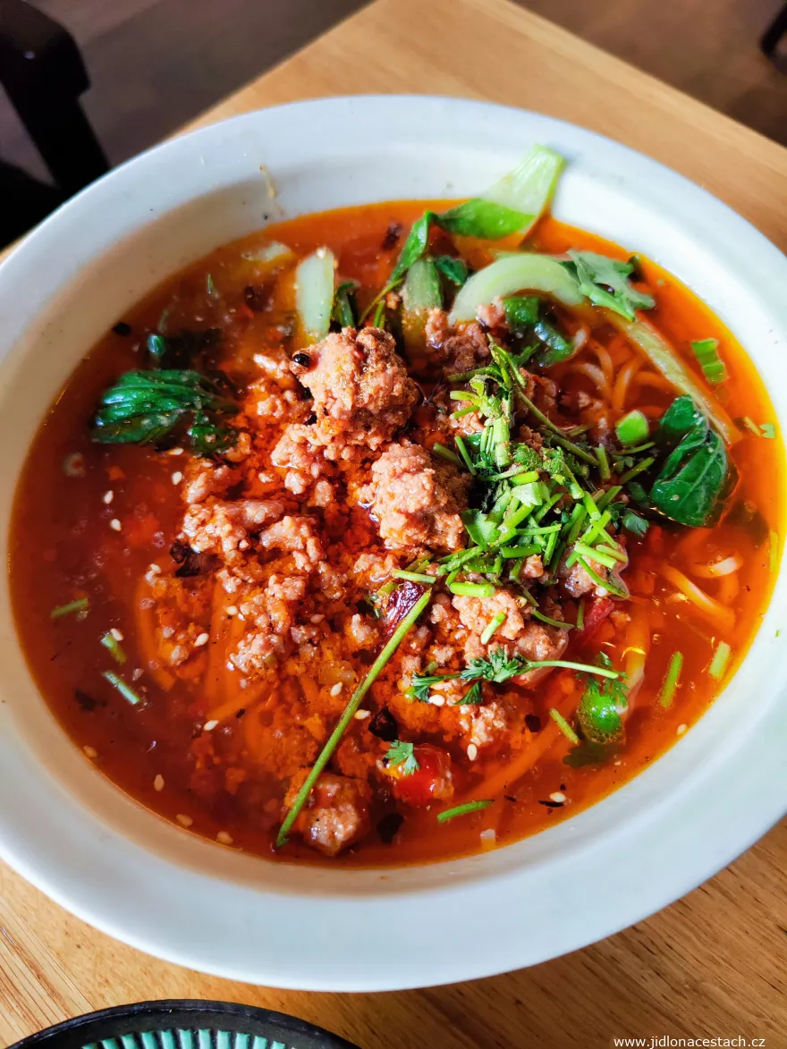 Mleté vepřové, kuřecí vývar, vaječné nudle, sezónní zelenina, červené chili a hořčičný list Chongqing