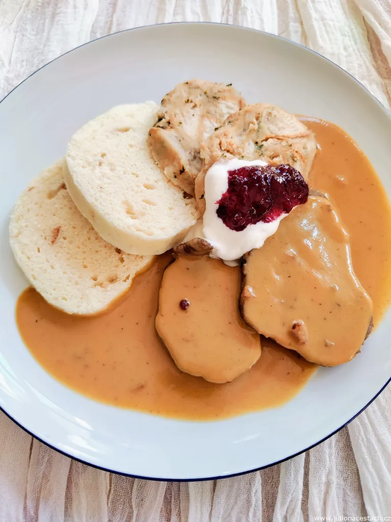 Svíčková na smetaně with two kinds of dumplings, whipped cream, cranberries