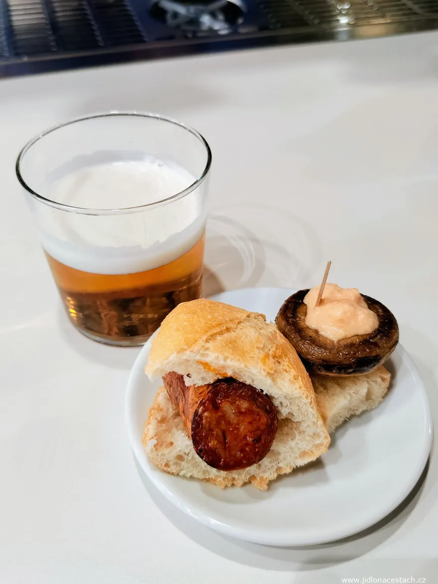 Typická porce jídla a pití v rámci txikiteo - dvě pintxos a malá sklenička piva (zurito de cerveza).