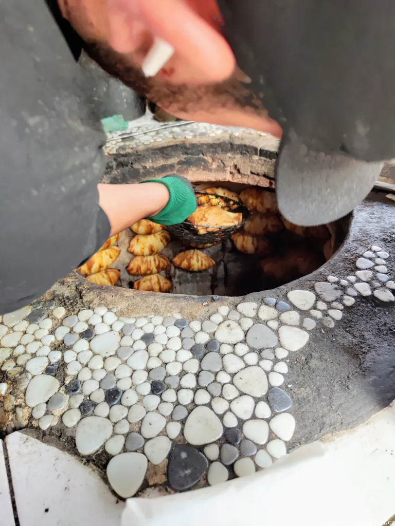 Removing samsa from the tandyr oven.