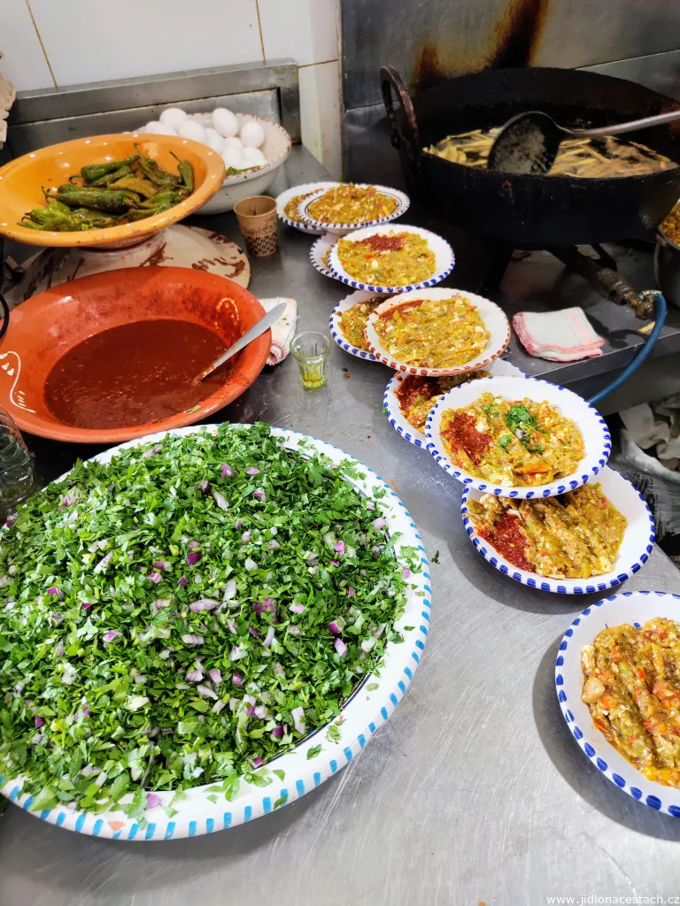 Zubereitung von Kafteji. Auf der Arbeitsfläche liegen alle nötigen Zutaten: Eier, frittierte grüne Paprika, Harissa sowie gehackte Petersilie mit Zwiebel. Zubereitung von Kafteji. Auf der Arbeitsfläche liegen alle nötigen Zutaten: Eier, frittierte grüne Paprika, Harissa sowie gehackte Petersilie mit Zwiebel.