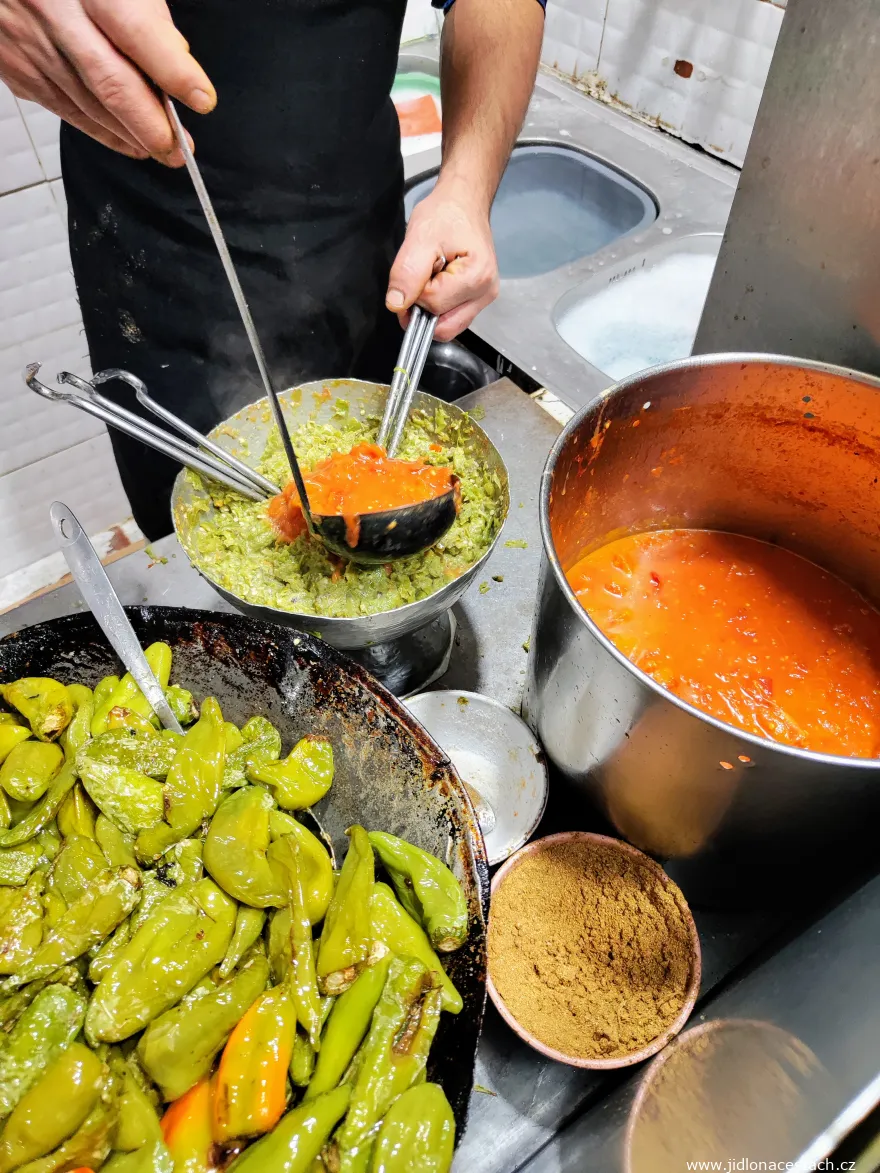Zubereitung von Kafteji. Zu den fein gehackten frittierten grünen Paprika kommt Harissa. Im Gefäß sind auch die speziellen Messer (Haken) zu sehen, mit denen die Zutaten gehackt und zugleich vermischt werden. Zubereitung von Kafteji. Zu den fein gehackten frittierten grünen Paprika kommt Harissa. Im Gefäß sind auch die speziellen Messer (Haken) zu sehen, mit denen die Zutaten gehackt und zugleich vermischt werden.