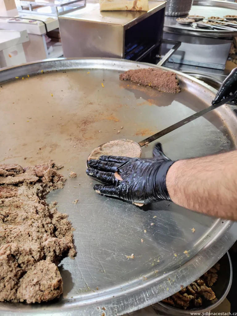 Beryani: Das Lammhackfleisch wird in spezielle Pfännchen gefüllt und kurz gegrillt. Im rechten Teil der großen Pfanne ist gehackte Lammlunge zu sehen, ein weiterer wichtiger Bestandteil des Gerichts.