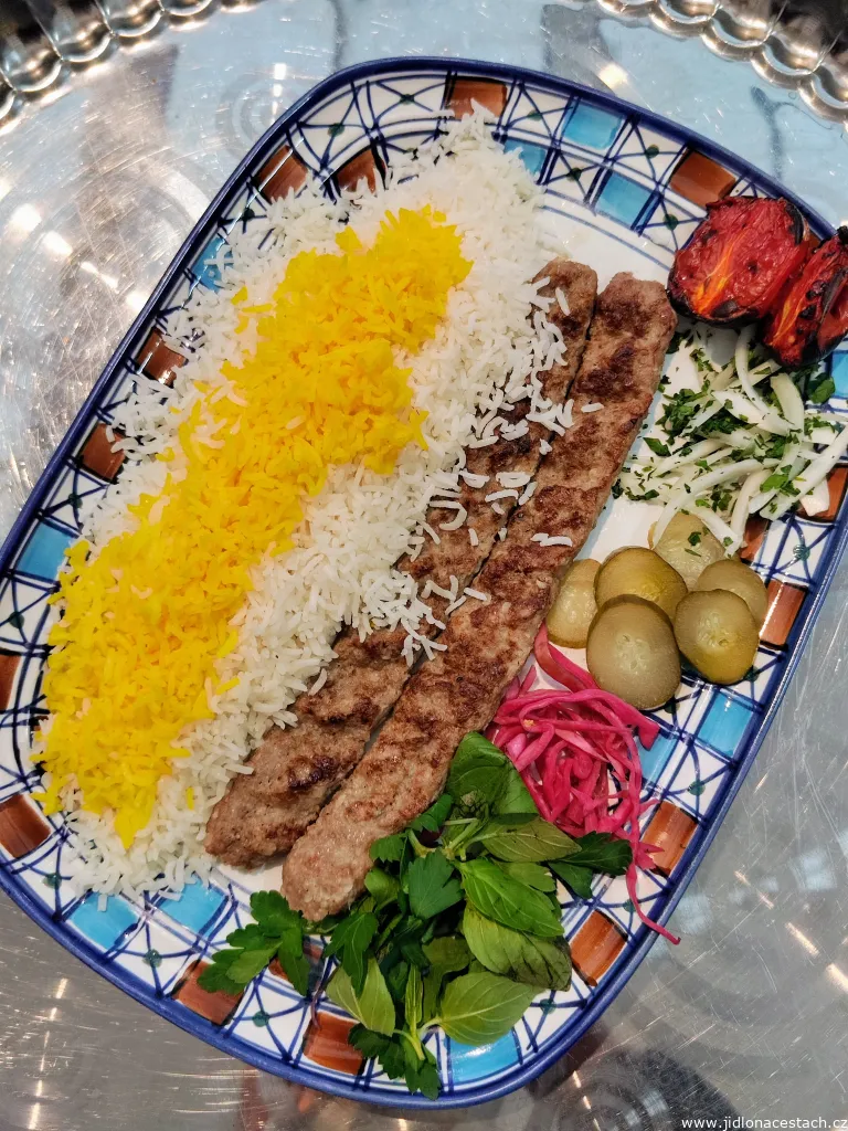 Typické íránské jídlo: kabab koobideh (mleté maso grilované na ohni) s rýží, bylinkami a zeleninou. 