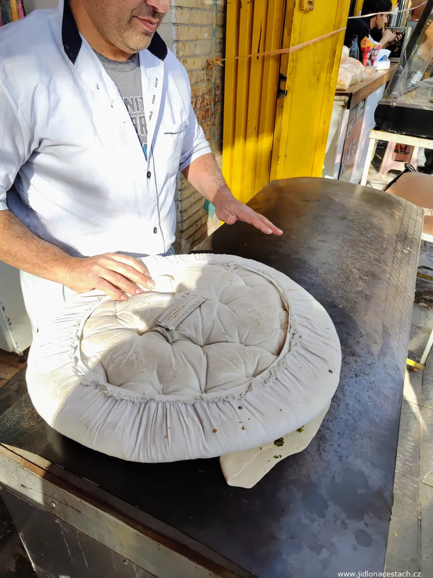Kalaneh : la galette est déposée avec précaution sur la plaque de métal brûlante. Kalaneh : la galette est déposée avec précaution sur la plaque de métal brûlante.