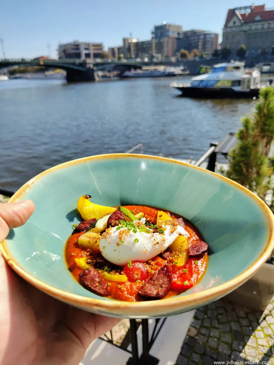 Brunch Občanská plovárna: variace na lečo - omáčka z pečených paprik a rajčat, grilované papriky, cuketa, papriková klobása, zastřené vejce, nakládaná cherry rajčátka, cibulová drobenka a bylinky.