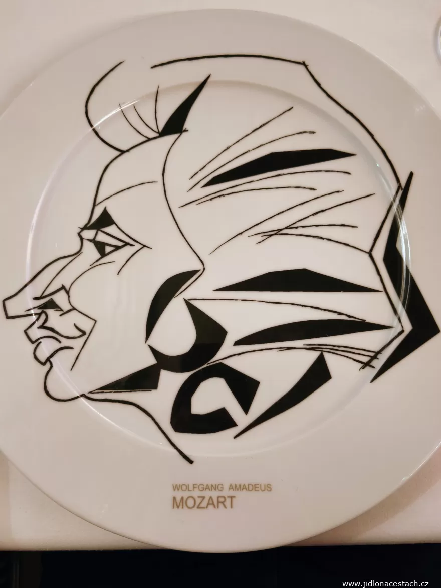 Coda: a charger plate with a caricature of Mozart.