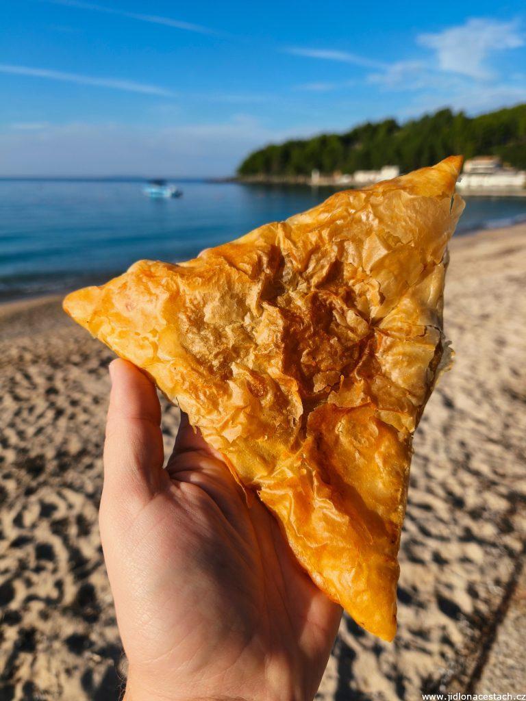 Trojúhelníkový byrek plněný masem (v podobě samostatné taštičky). Trojúhelníkový byrek plněný masem (v podobě samostatné taštičky).